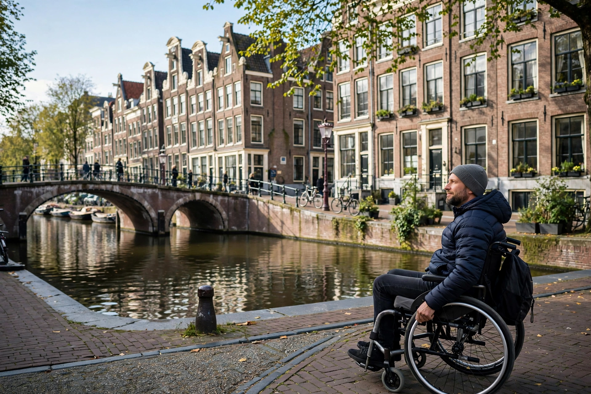 Wheelchair user enjoying the view along an Amsterdam canal with historic houses