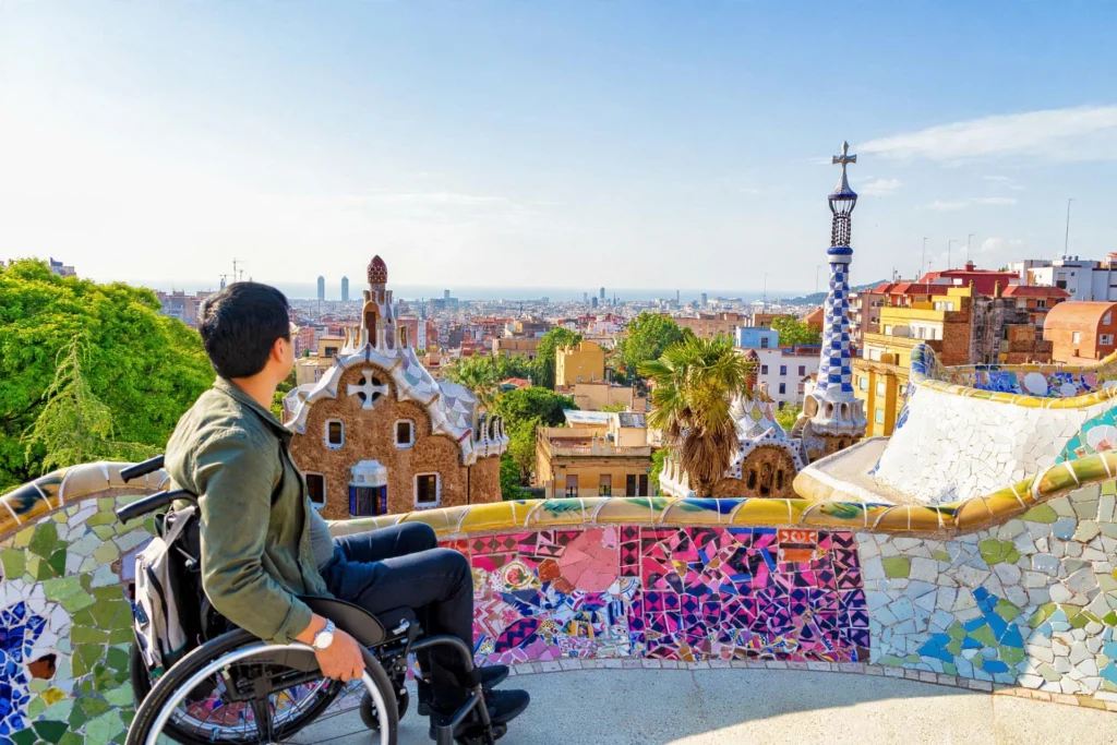 Wheelchair user enjoying the view from the Park Güell mosaic terrace in Barcelona